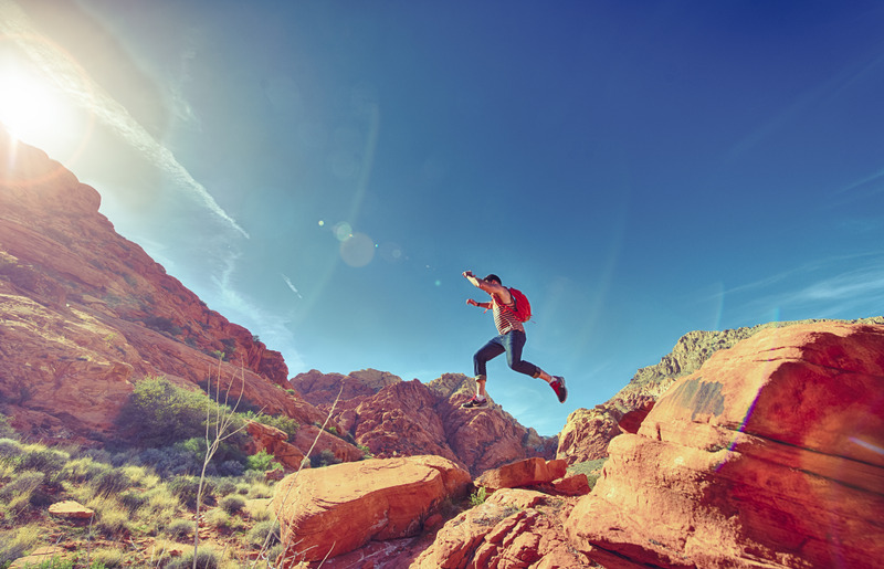 man jumping happily over rocks | Burnaby and New Westminster | Pacific Health Sports Therapy